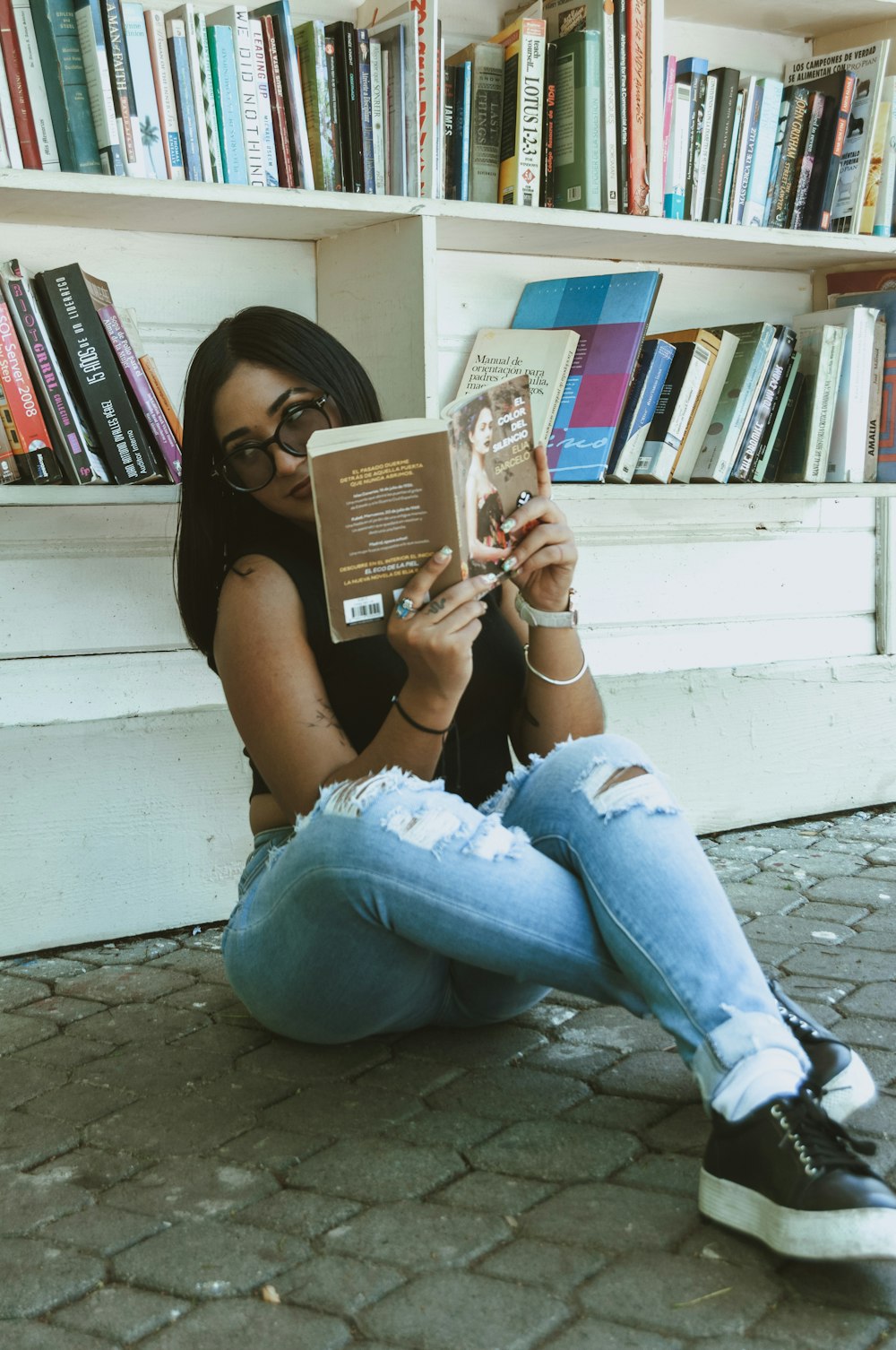 a woman sitting on the ground reading a book