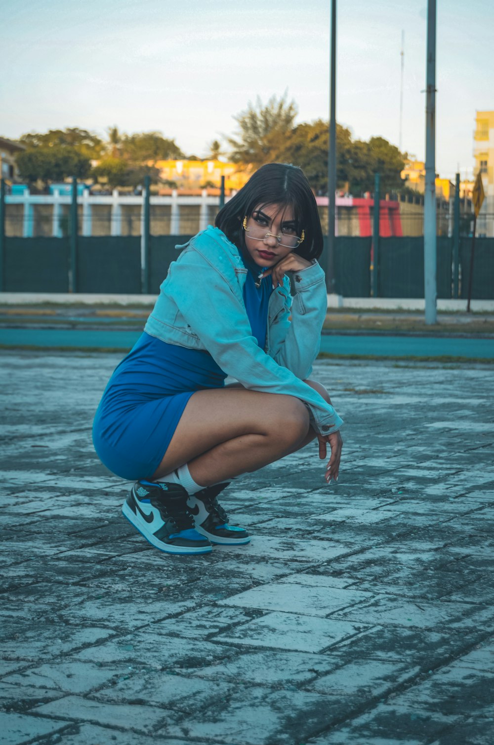 a woman squatting on the ground with her hand on her face