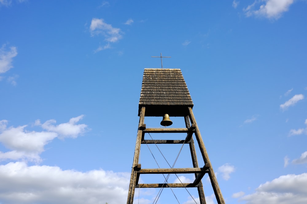 a tall wooden tower with a cross on top