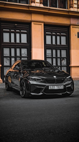 A sleek black taxi parked near Malaga AVE station with luggage loaded.