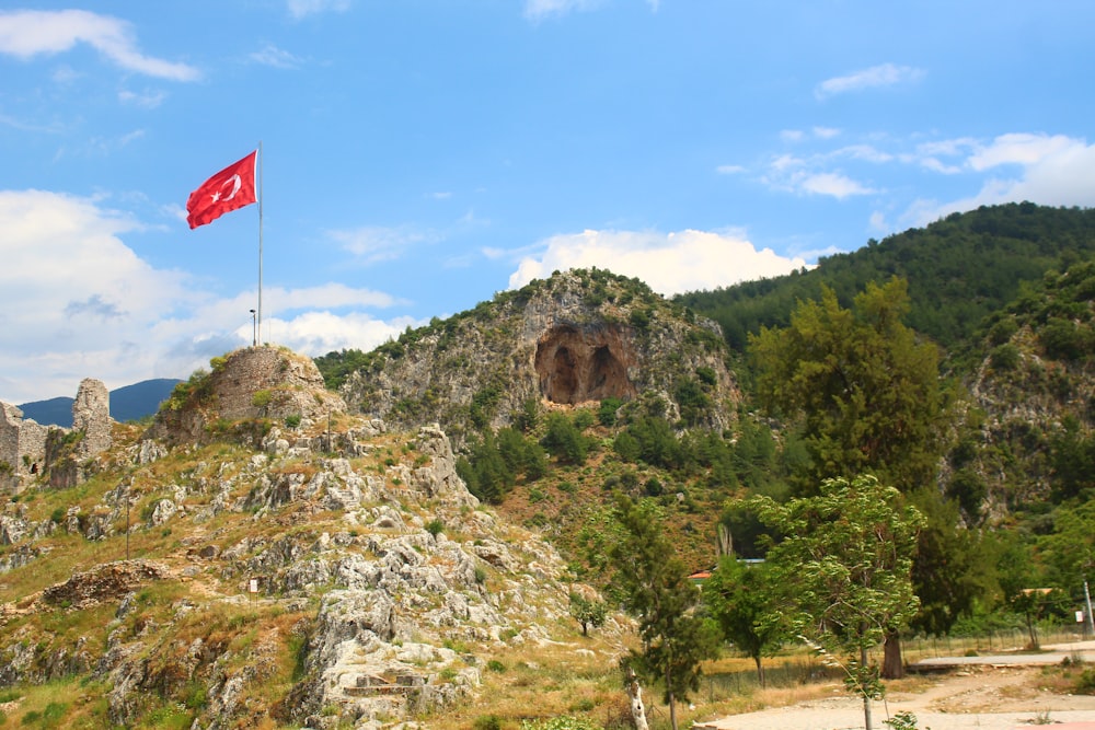 a flag flying on top of a rocky mountain