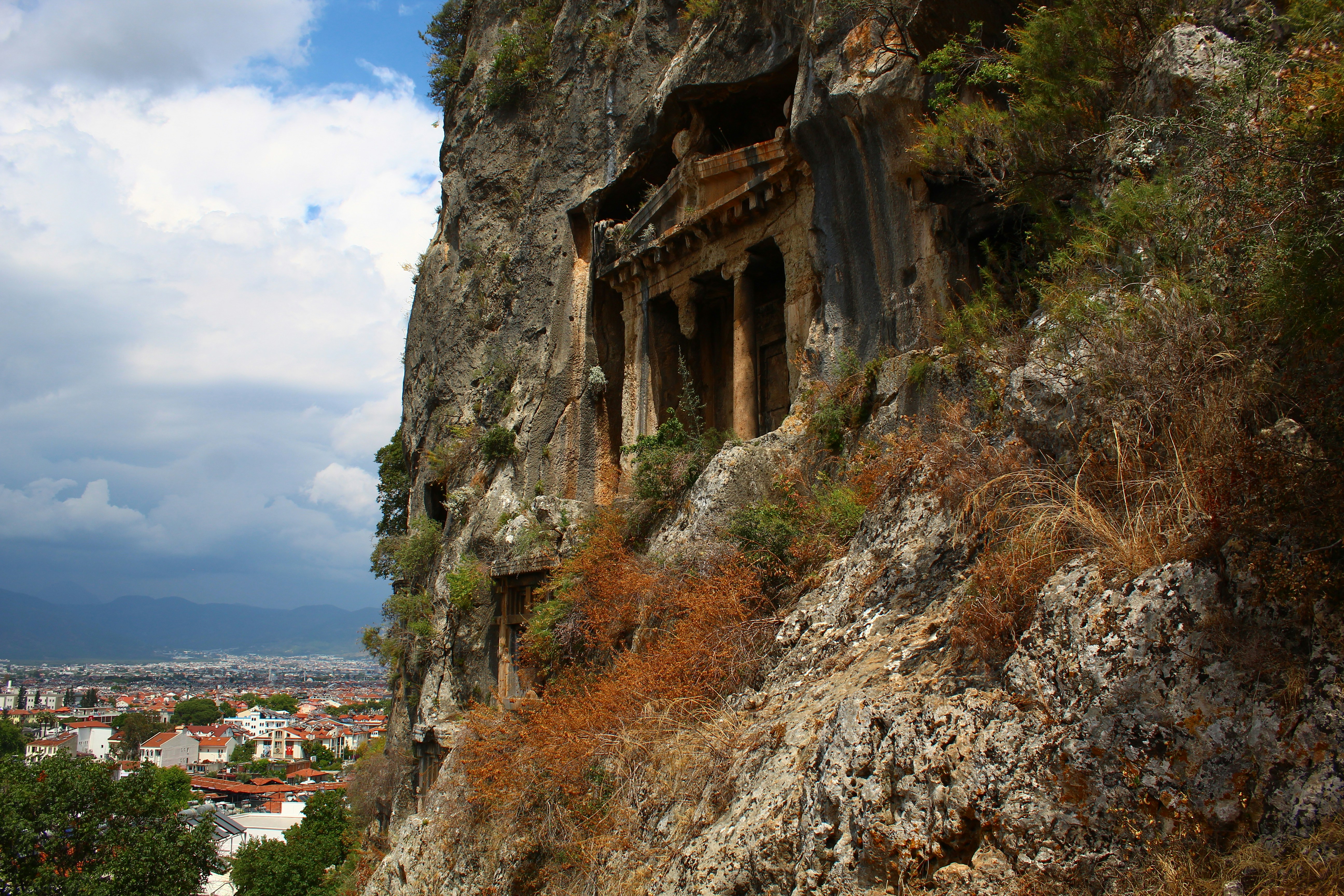 a rocky cliff with a small cave in the middle of it