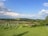 A serene farm landscape with children learning about plants and animals.