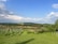 A serene farm landscape with children learning about plants and animals.