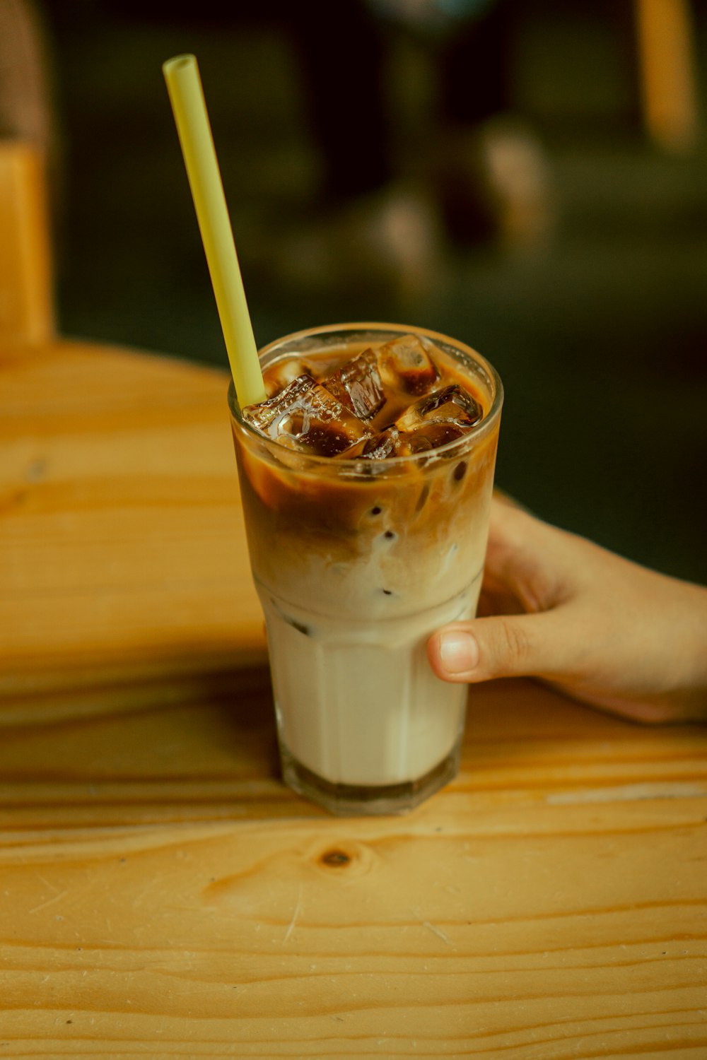 a person holding a drink with a straw in it