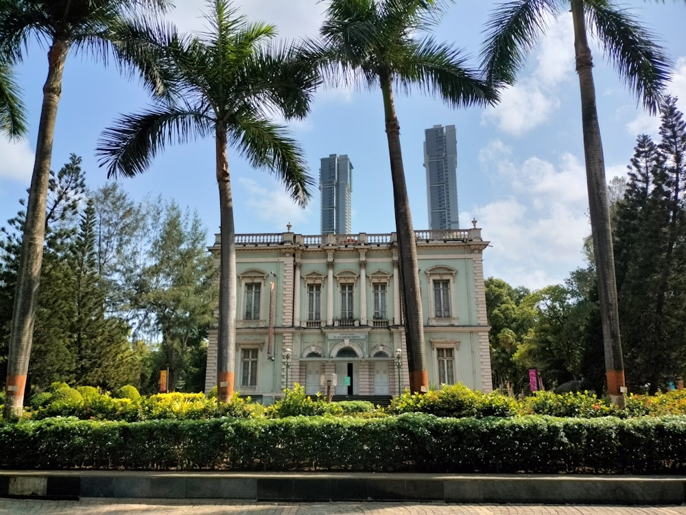 a large white building surrounded by palm trees