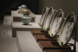 A bright, sunlit shelf displaying an array of cheerful, hand-glazed plates.
