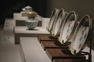 Close-up of intricately designed pital bowls and plates with warm lighting highlighting their texture.