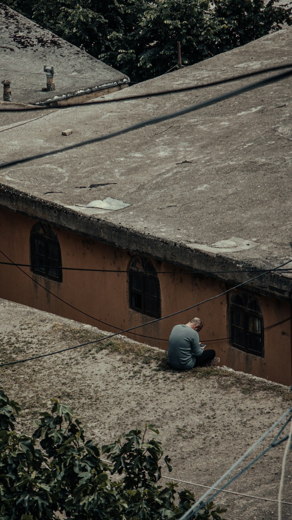 Un homme assis sur le toit d’un immeuble