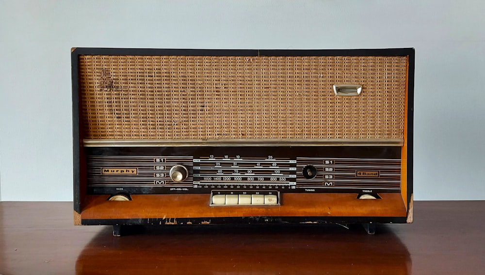 um rádio velho sentado em cima de uma mesa de madeira