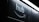 A dark image featuring the word 'hub' and an Amazon smile logo beneath a bright, white fluorescent light strip.