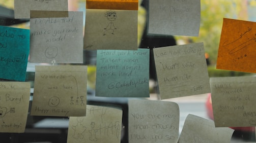 A close-up of handwritten English tips and motivational quotes on colorful sticky notes.