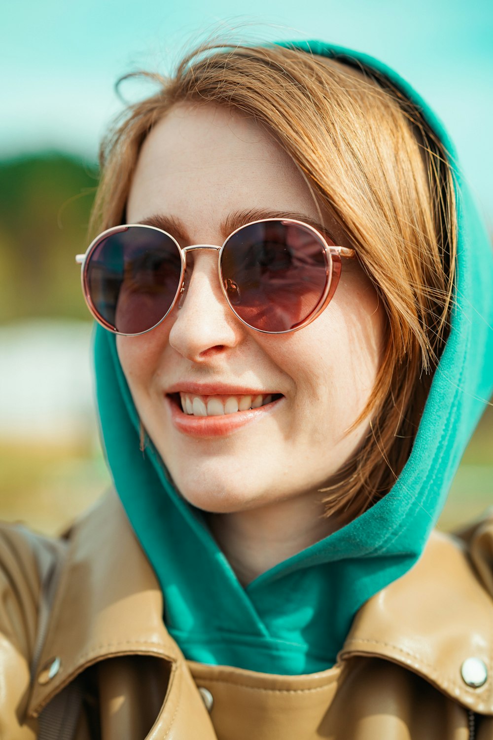 a woman wearing sunglasses and a green scarf
