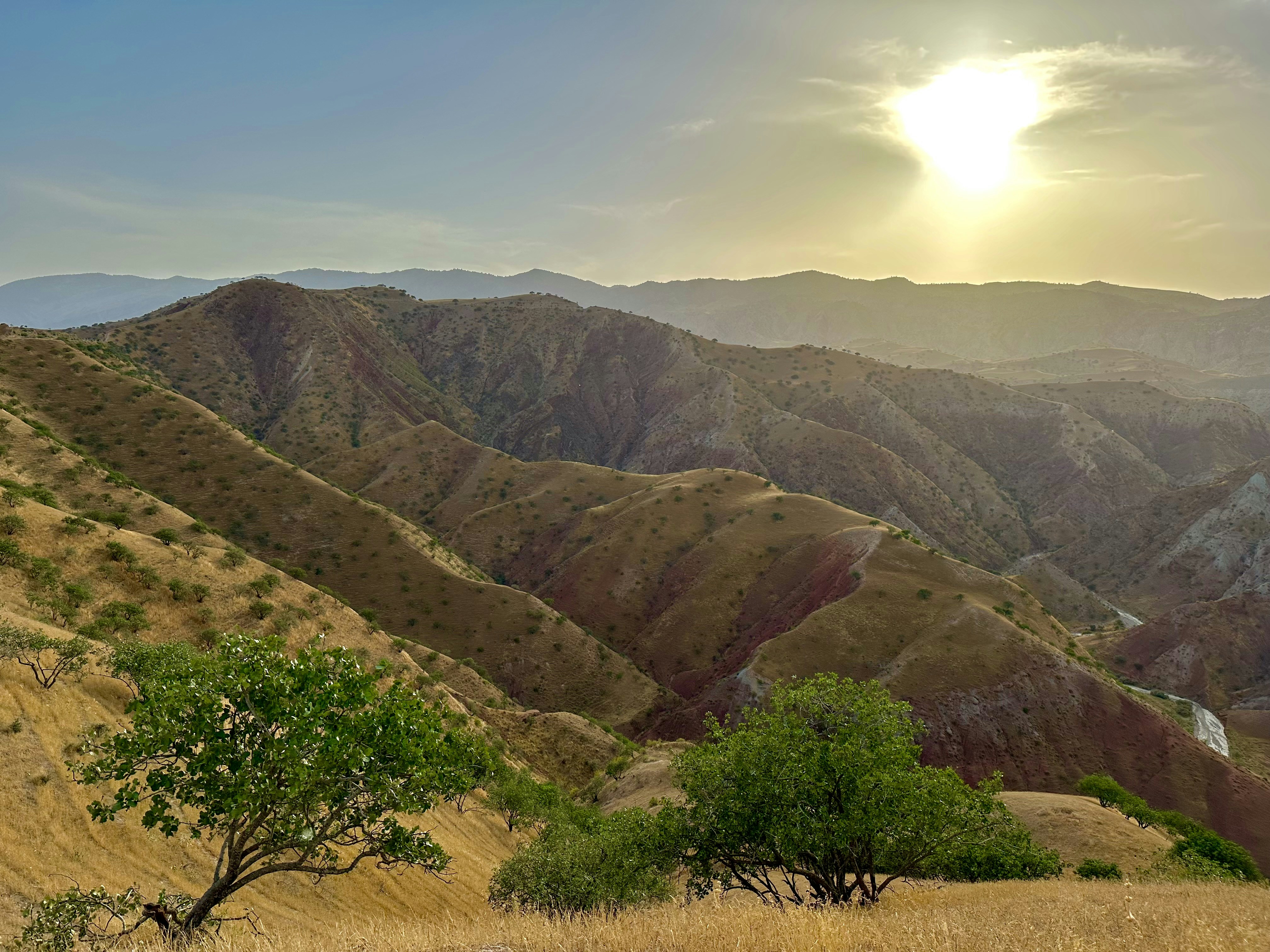 the sun is setting over a mountain range