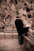 An artist sketching the ancient walls of a mountain monastery nestled in the hills.