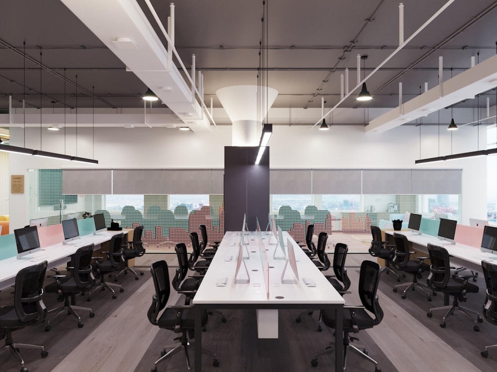 an office with a long white table and black chairs