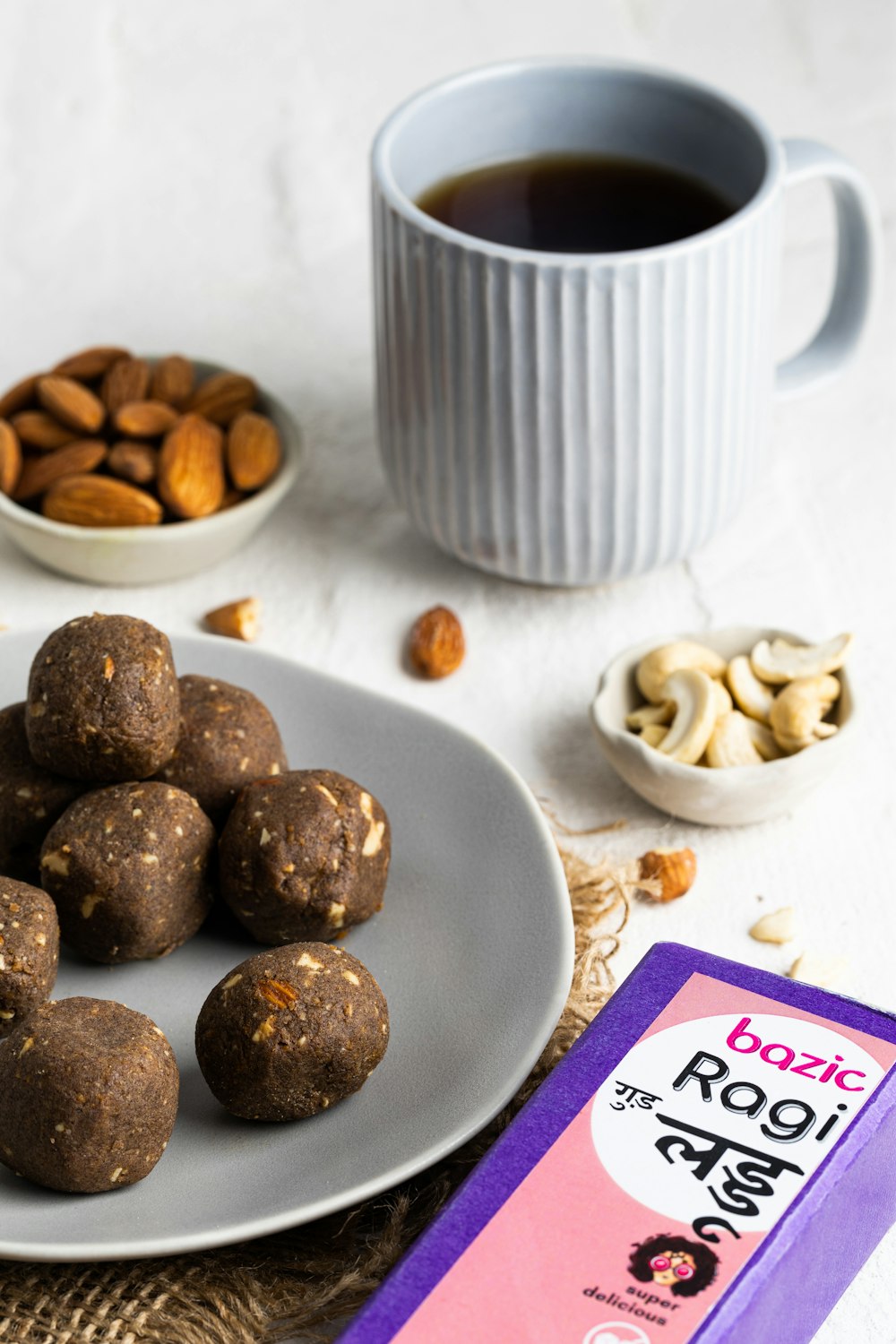 a plate of nuts next to a cup of coffee