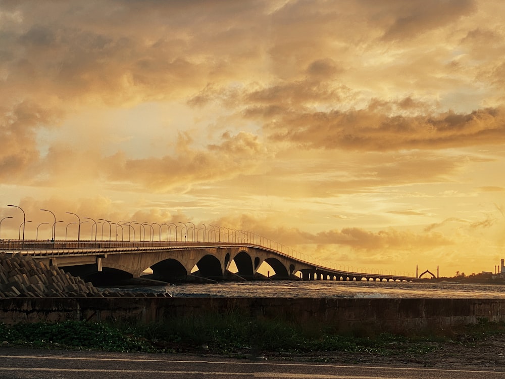 a large bridge over a body of water under a cloudy sky