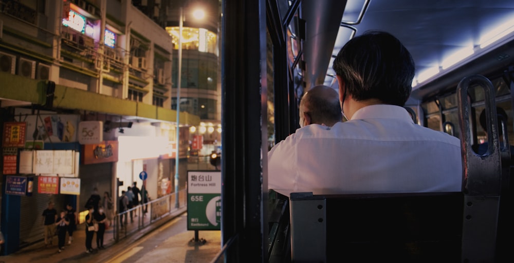 a man sitting on a bus looking out the window