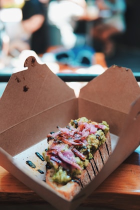a half eaten sandwich in a box on a table