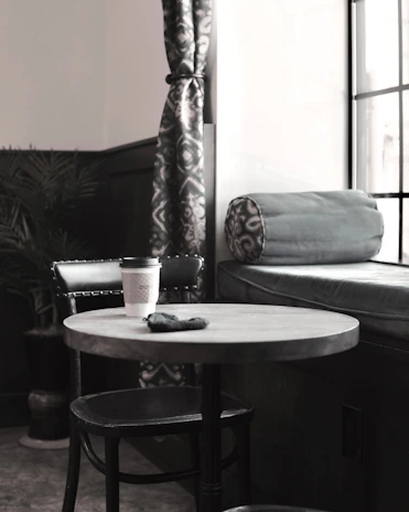 A cozy corner with a bag of Raizal coffee and a small plant beside it.