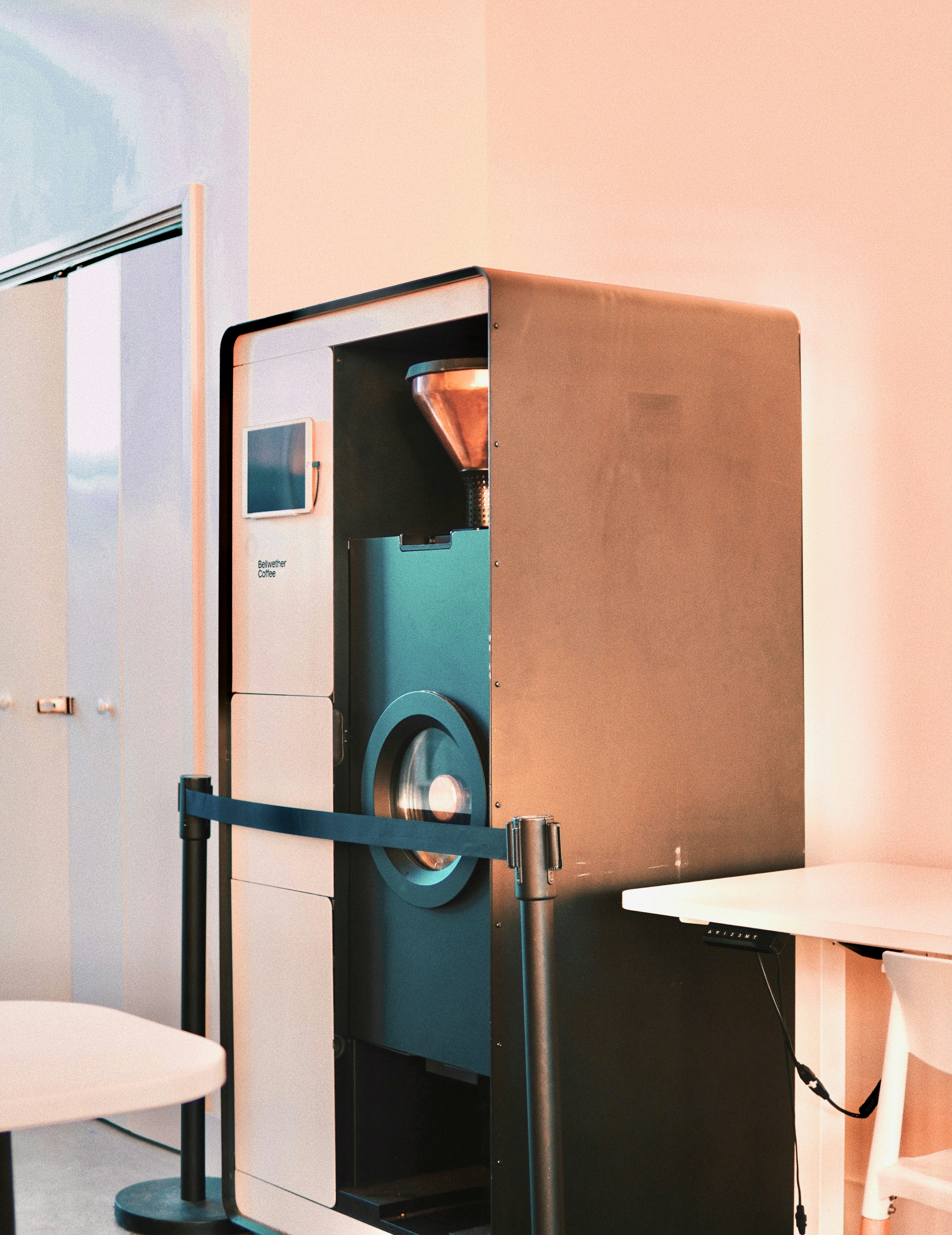 Specialty coffee roaster examining green beans under bright light, clean modern roastery, airy well-lit workspace