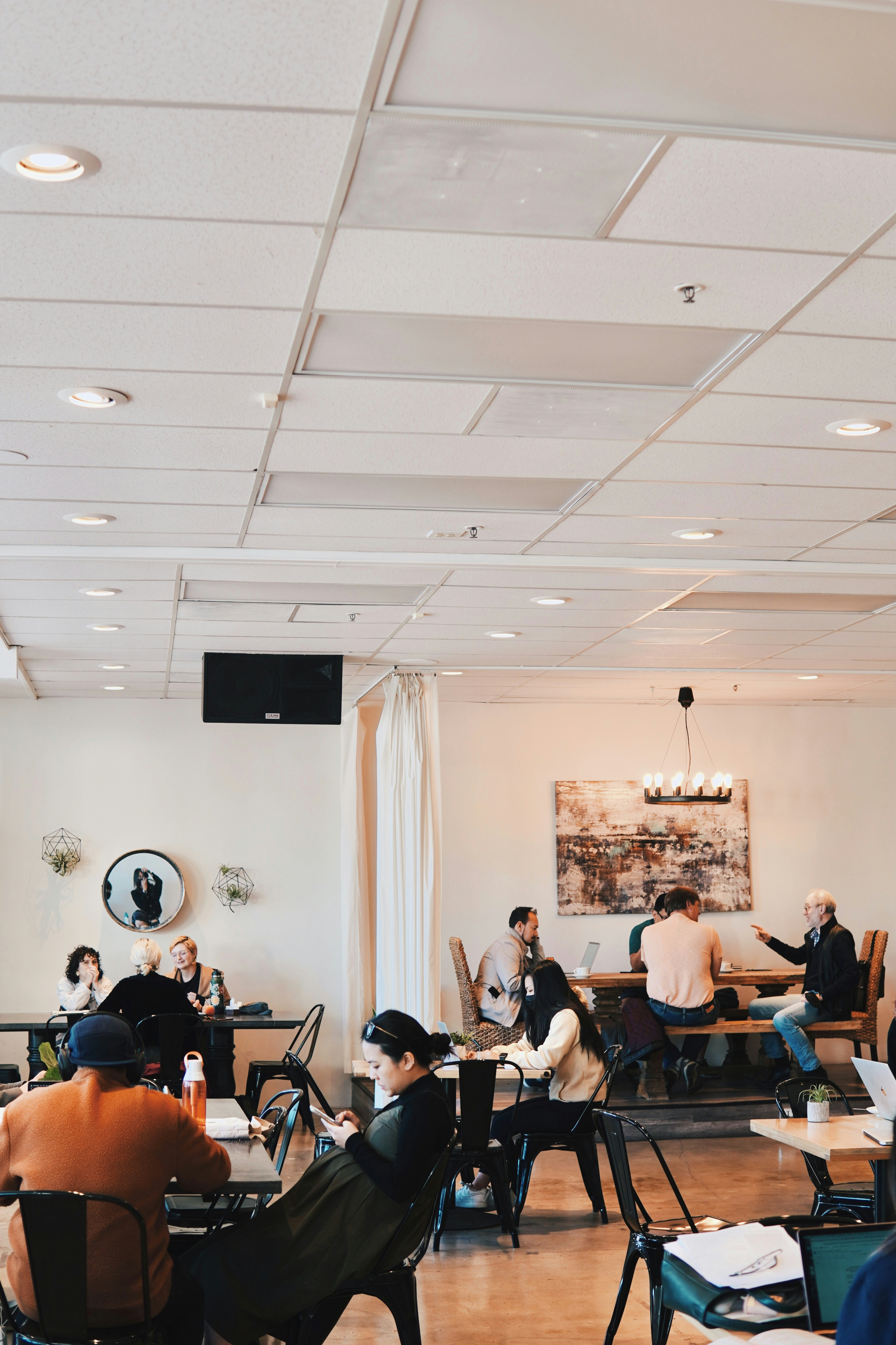 Young professional tasting wine in a bright modern wine bar, clean white walls and natural light