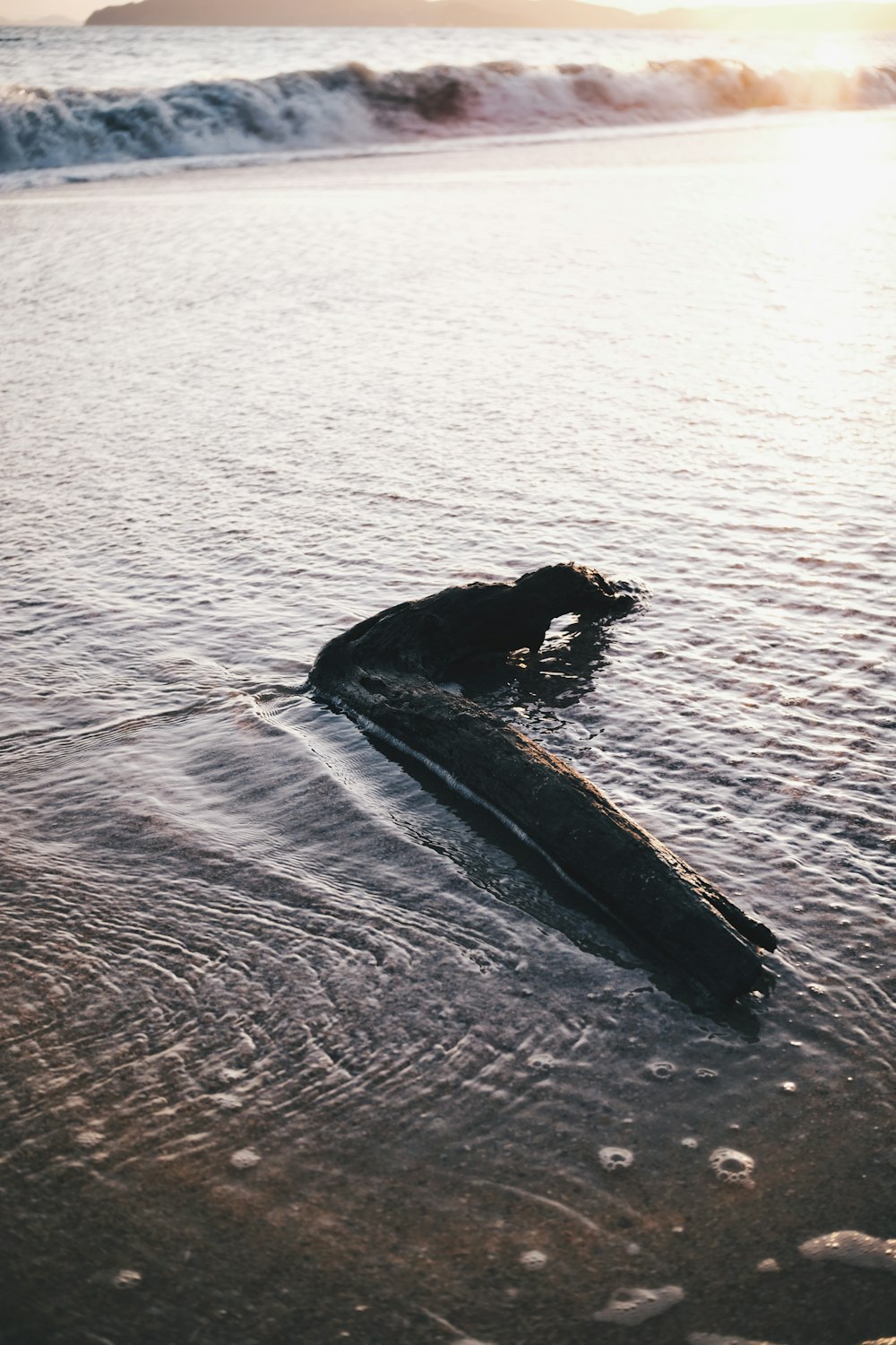 a surfboard laying in the water on a beach