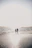 Warm cinematic image of a couple holding hands, bathed in late afternoon light at the beach.