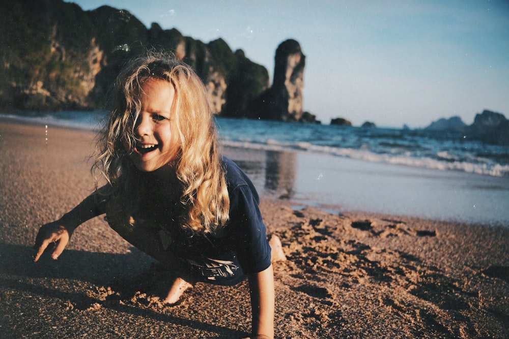 a young girl is playing on the beach