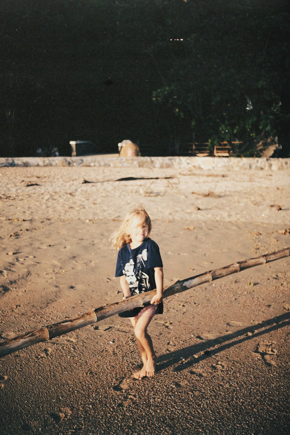 a little boy standing on top of a sandy beach