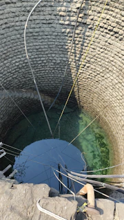 High-resolution photo of a drilling machine perfectly installed a fresh water well in a residential backyard