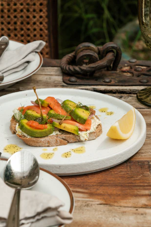 Close-up of a healthy keto meal with avocado, eggs, and nuts on a rustic wooden table.