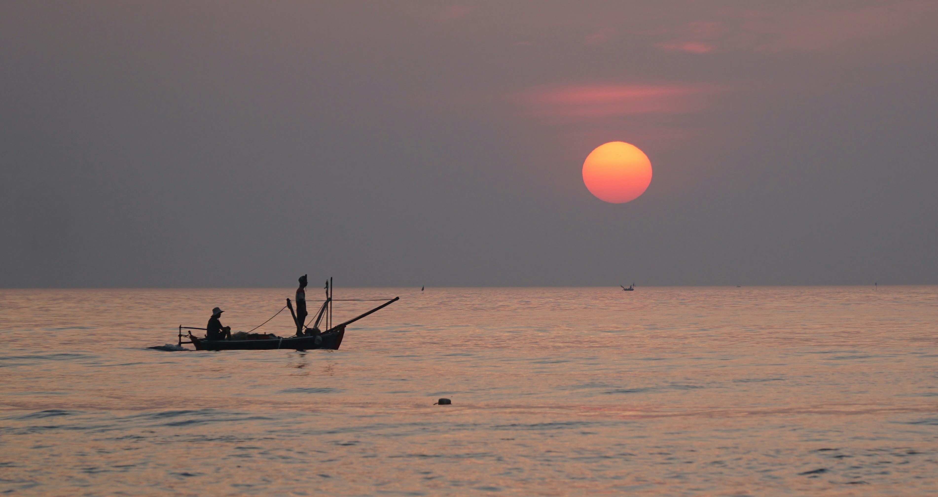 a small boat floating on top of a large body of water