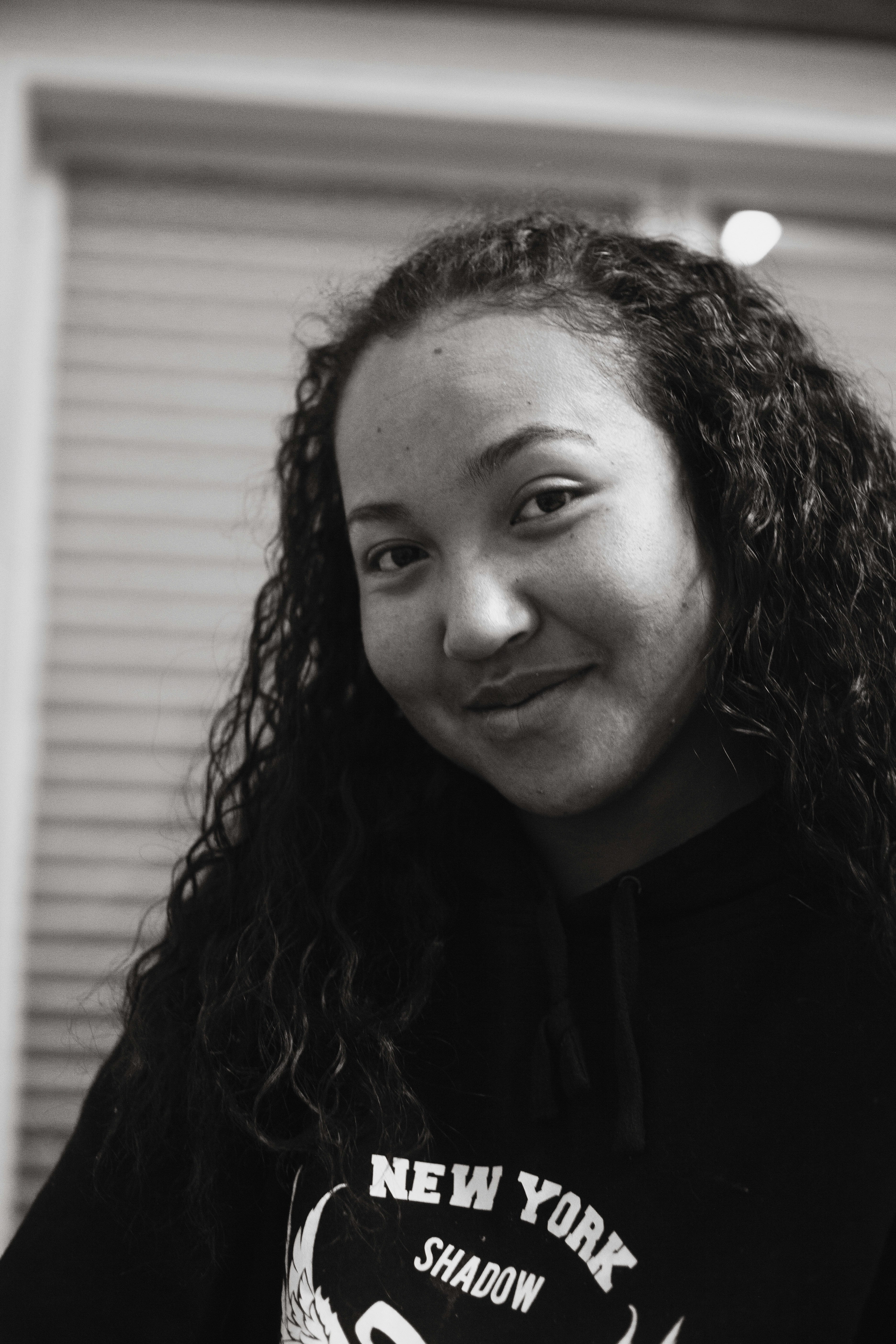 Young woman with straight black hair smiling gently, soft light portrait