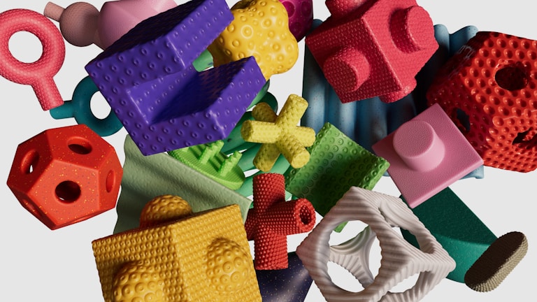 A collection of multicolored, textured geometric shapes are scattered on a light background. The objects vary in form, including cubes, spheres, rings, and complex shapes, each with distinct surface textures such as bumps and grooves. The arrangement appears random, creating a visually engaging and playful composition.