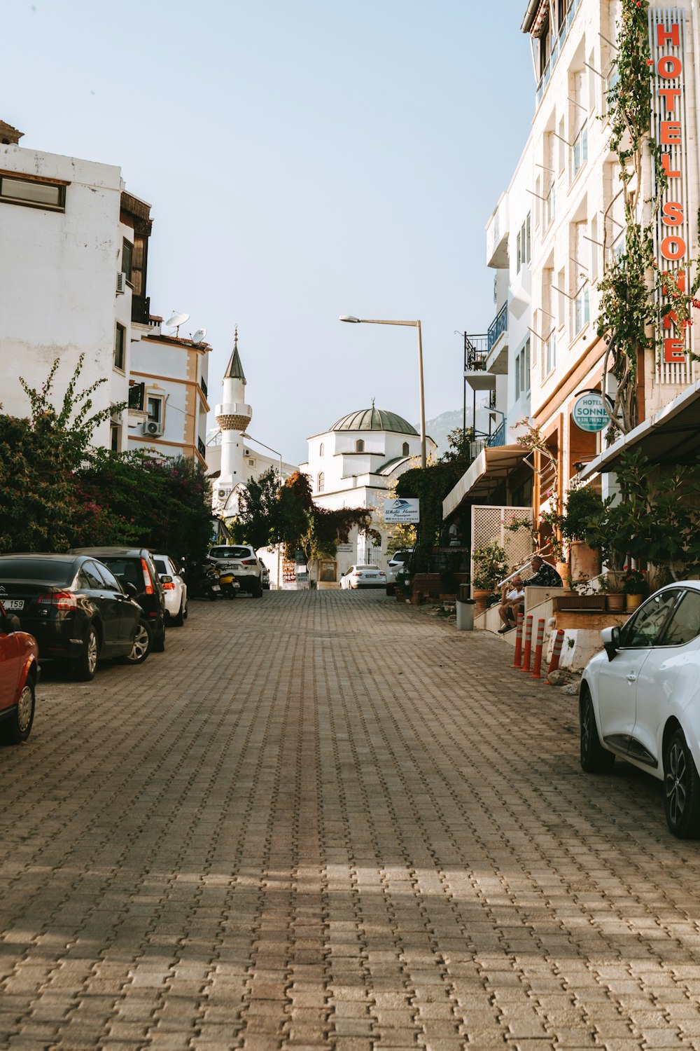 una strada con auto parcheggiate su entrambi i lati di esso