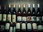 Bottles of organic wine arranged on a wooden shelf with vineyard scenery in the background