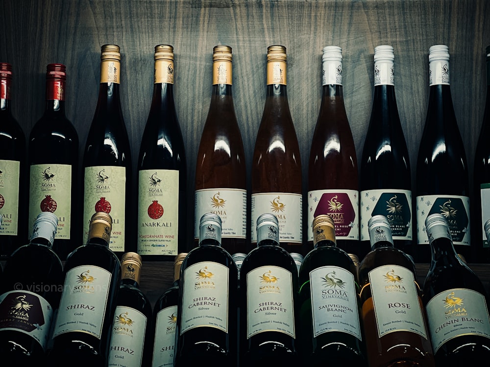 a bunch of wine bottles lined up on a shelf