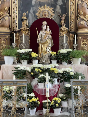 A serene altar decorated with yellow flowers and candles dedicated to Mãe Oxum.