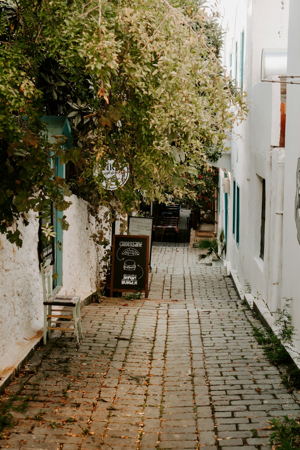 a cobblestone street lined with white buildings