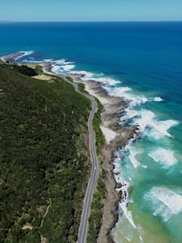 an aerial view of a road next to the ocean