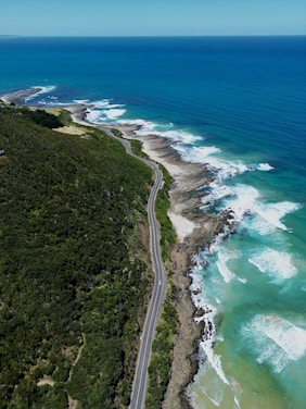 an aerial view of a road next to the ocean