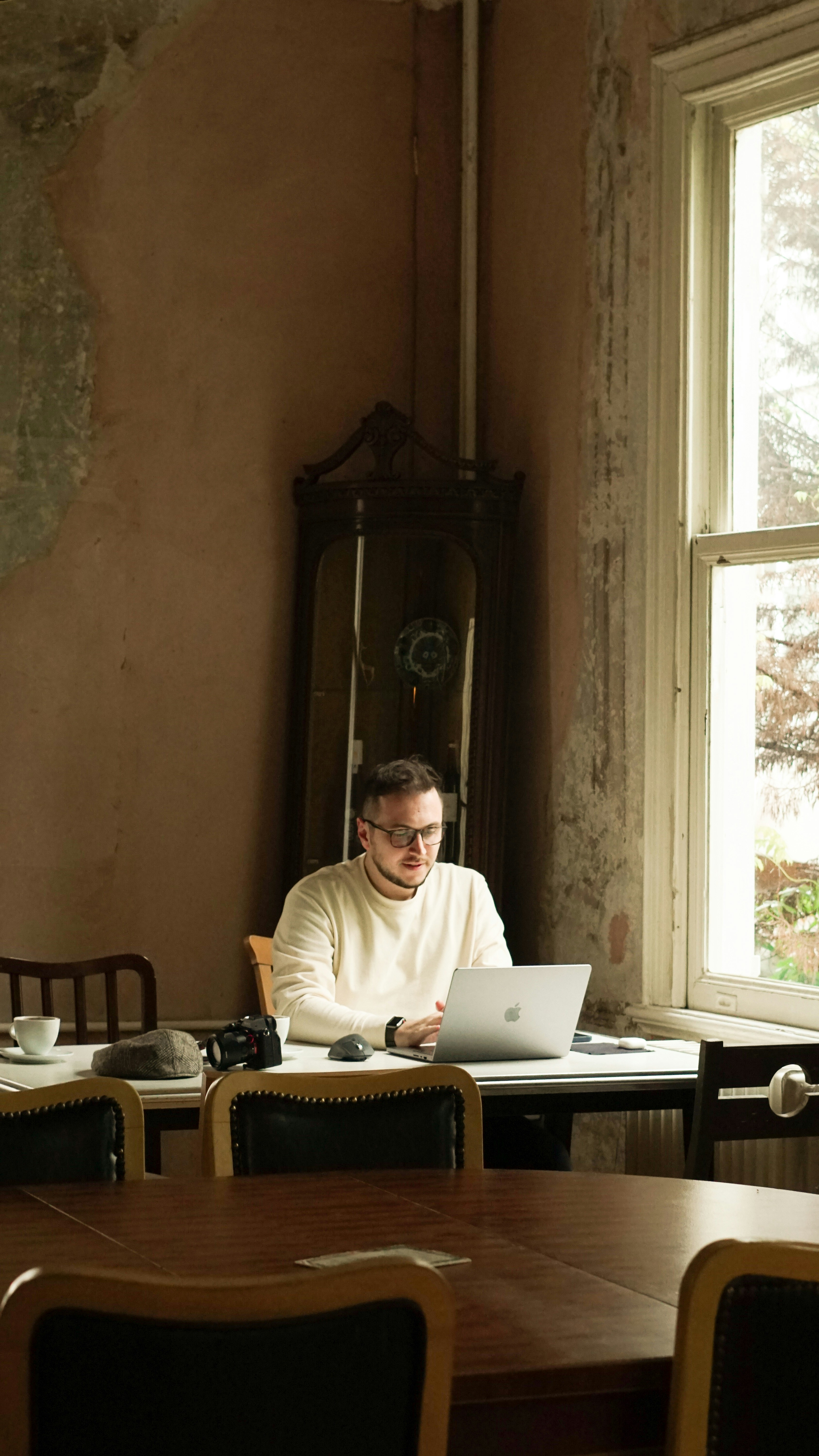 a man sitting at a table using a laptop computer