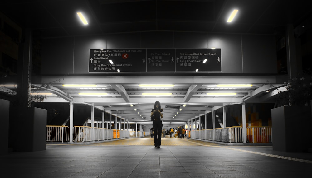 a woman is standing in the middle of a walkway