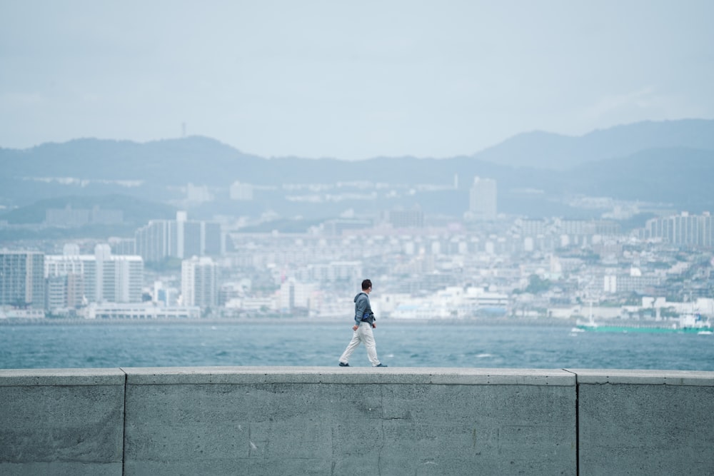 a man walking along the edge of a large body of water