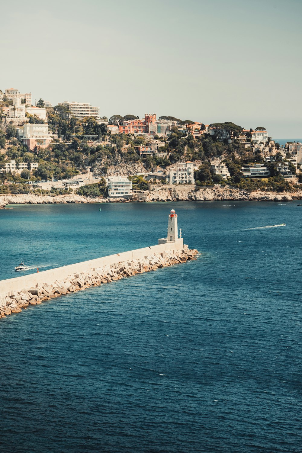 a light house sitting on the edge of a body of water