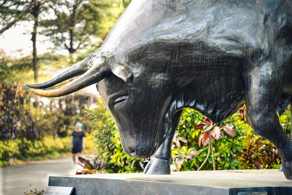 a statue of a bull in a park
