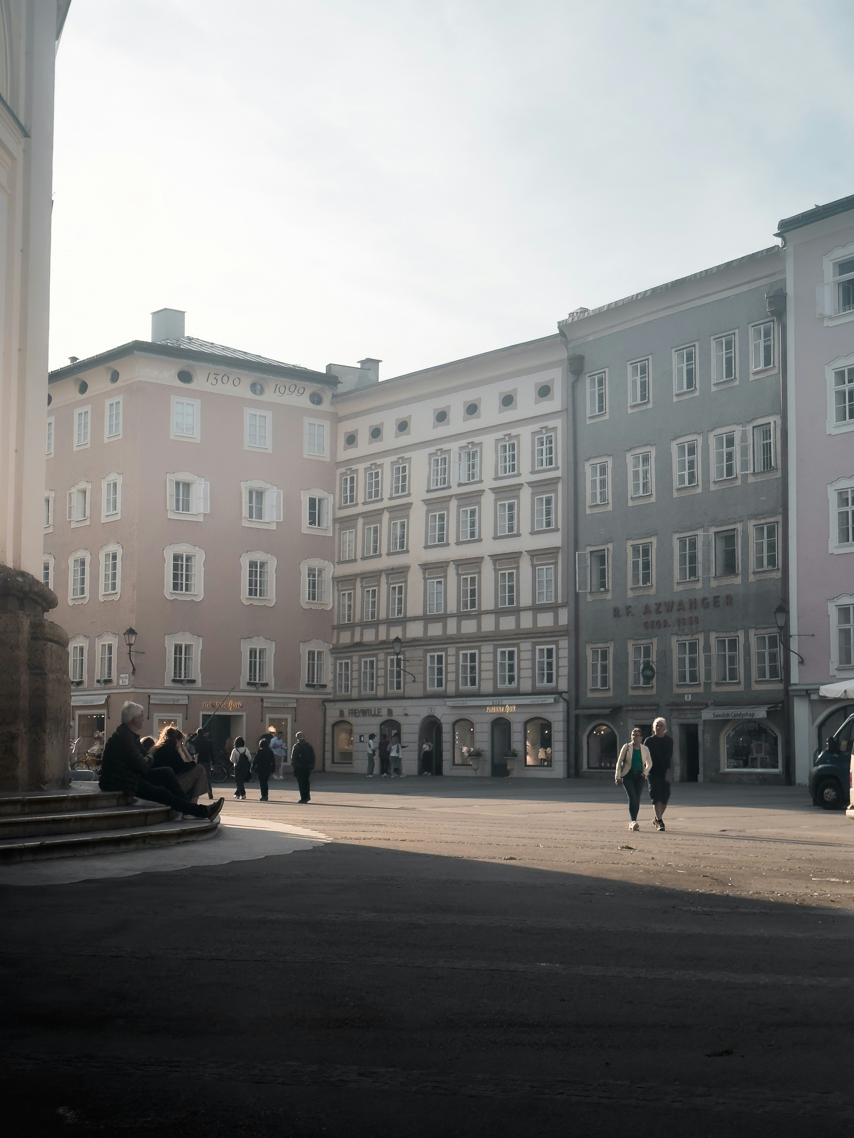 Un gruppo di persone che camminano lungo una strada accanto a edifici alti