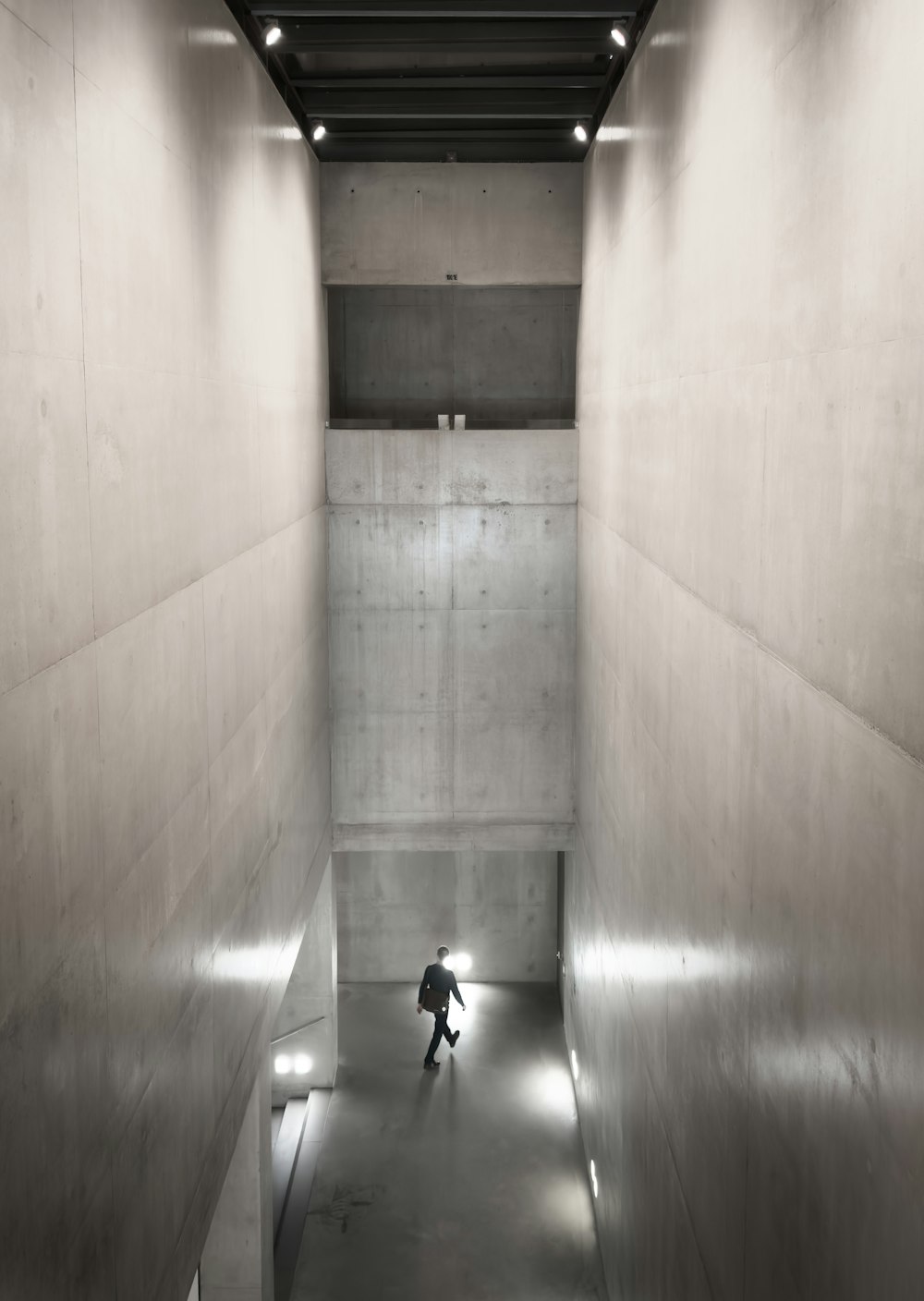 a person walking down a long hallway in a building